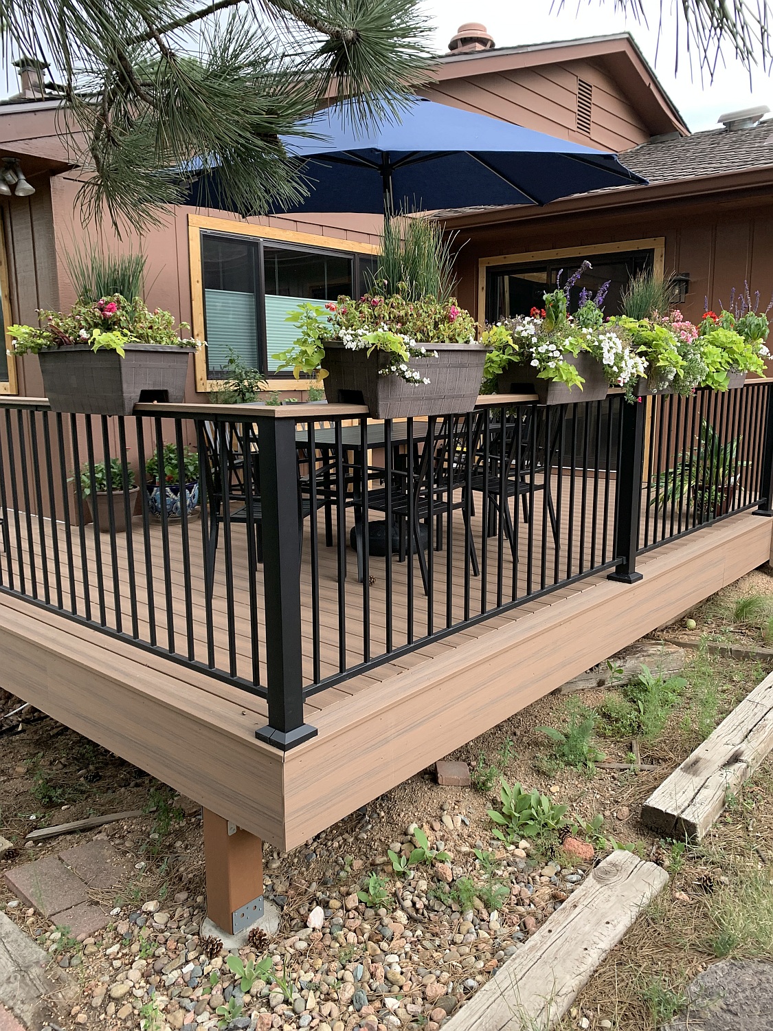 A gorgeous outdoor living space created with a composite deck. The homeowner has added a dining area and flower boxes along the railing.