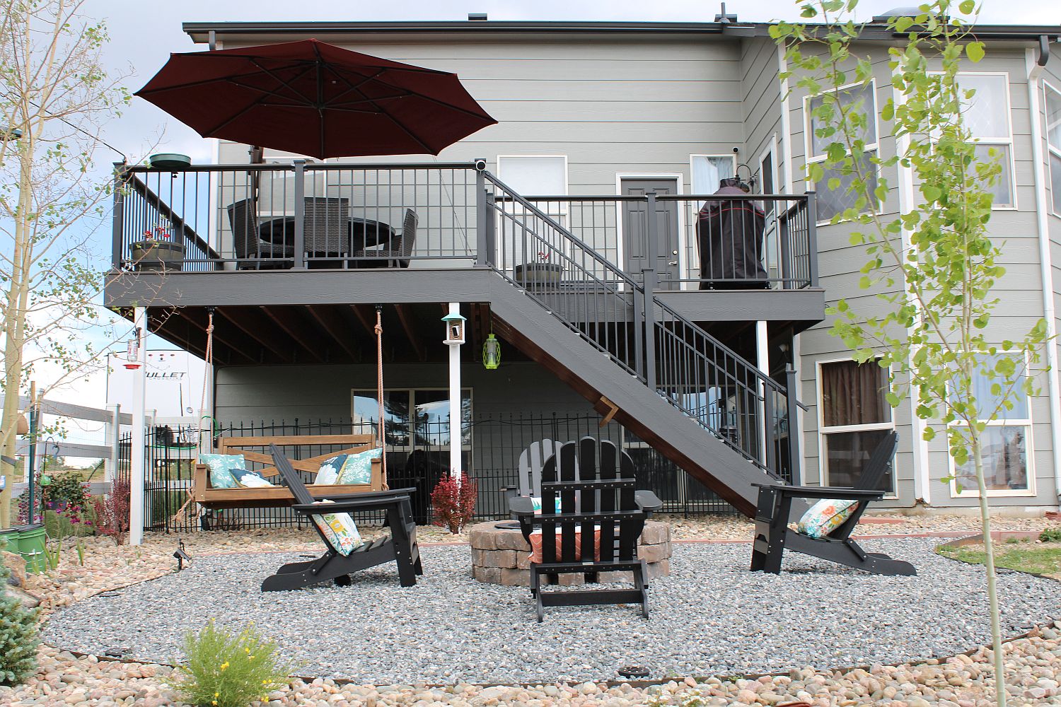 Outdoor living area consisting of fire pit and chairs and an elevated composite deck.