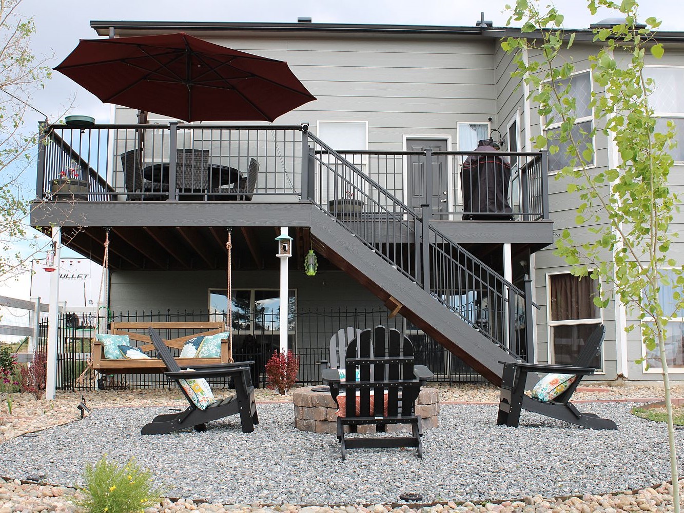 Beautiful outdoor living space created by building a composite deck with stairs leading down to a fire pit area