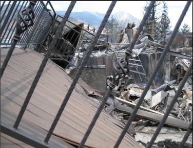 Shows what is left of a house destroyed by wildfire, but the composite deck is still whole.