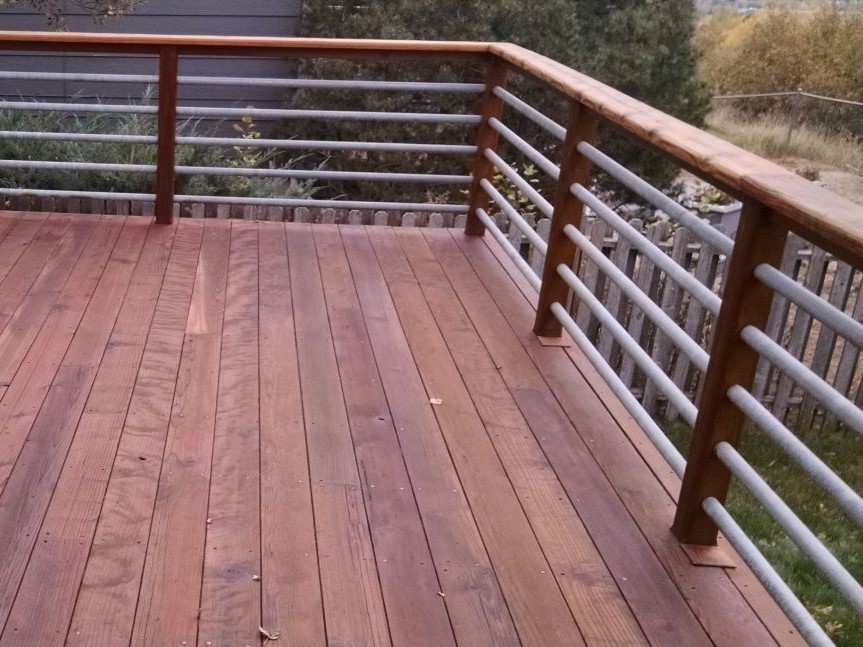 Redwood deck railing with horizontal, round, metal balusters in brushed steel