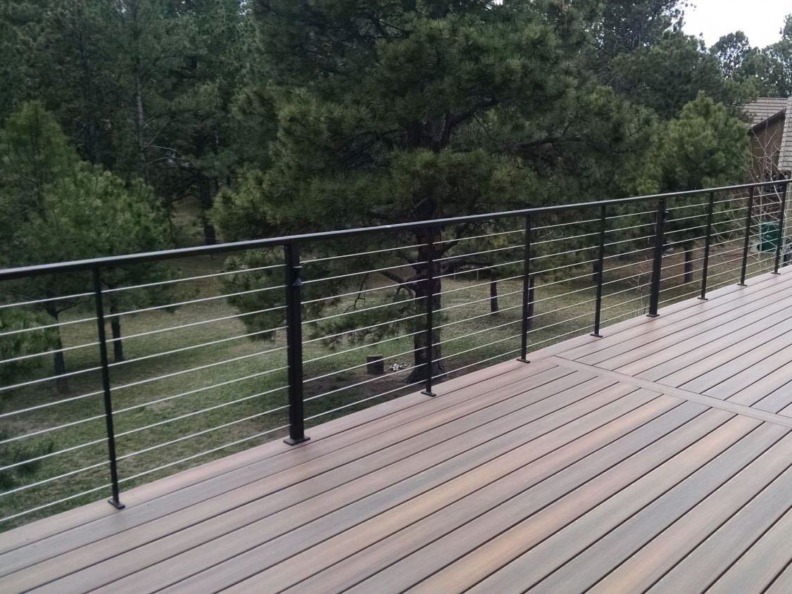 Composite deck with a custom designed metal railing featuring horizontal stainless steel cables.