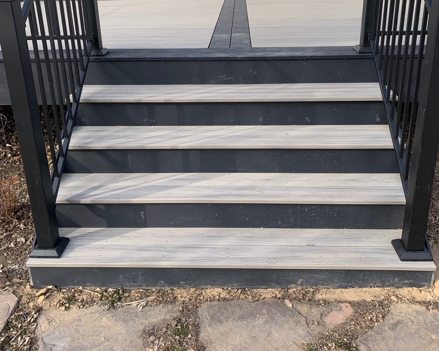 Composite deck staircase. It has light gray treads with a dark slate riser to create a beautiful contrast.