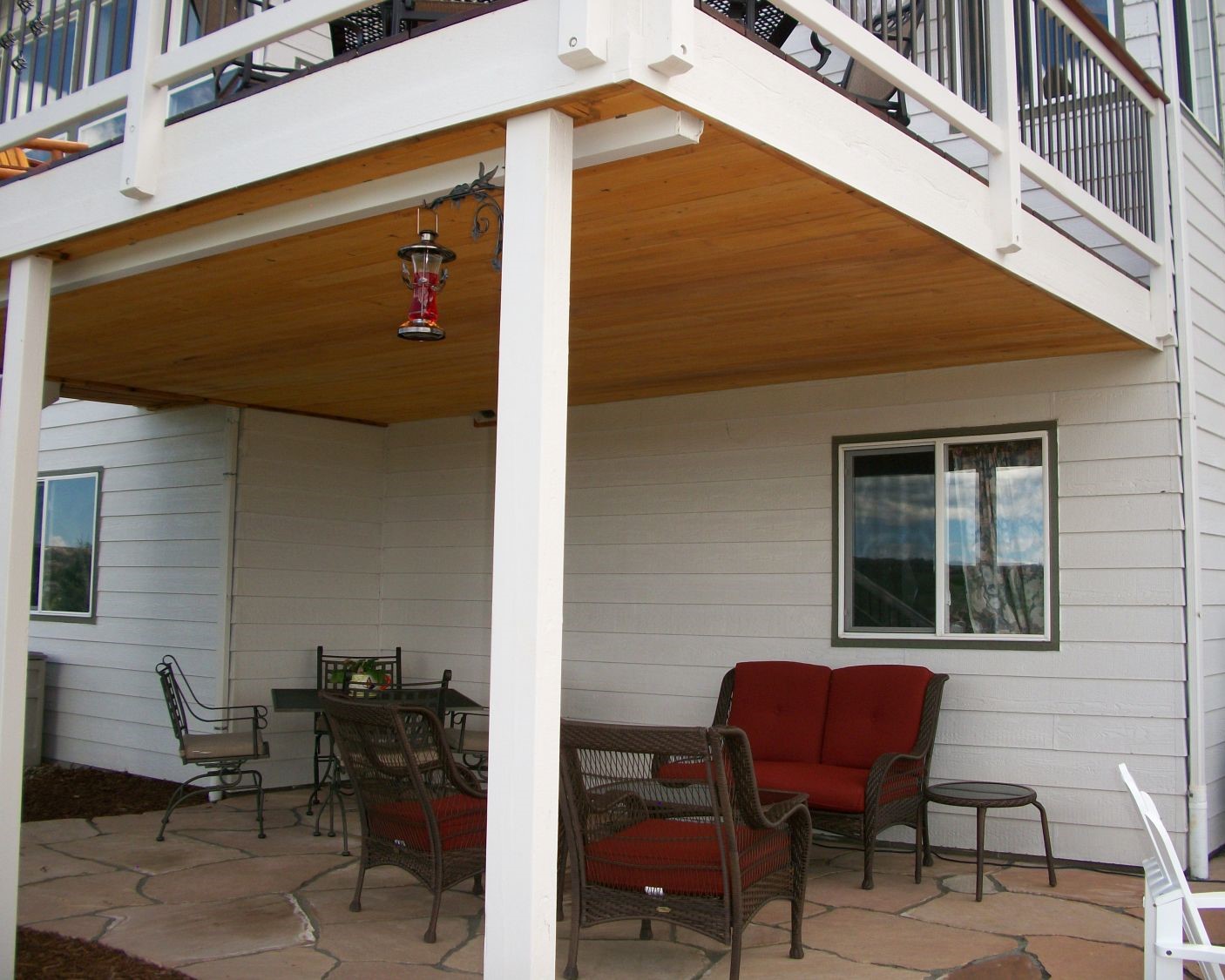 Elevated deck with an under-deck drainage system featuring a tongue and groove ceiling. This allows an area for entertaining below the deck that will be kept dry.